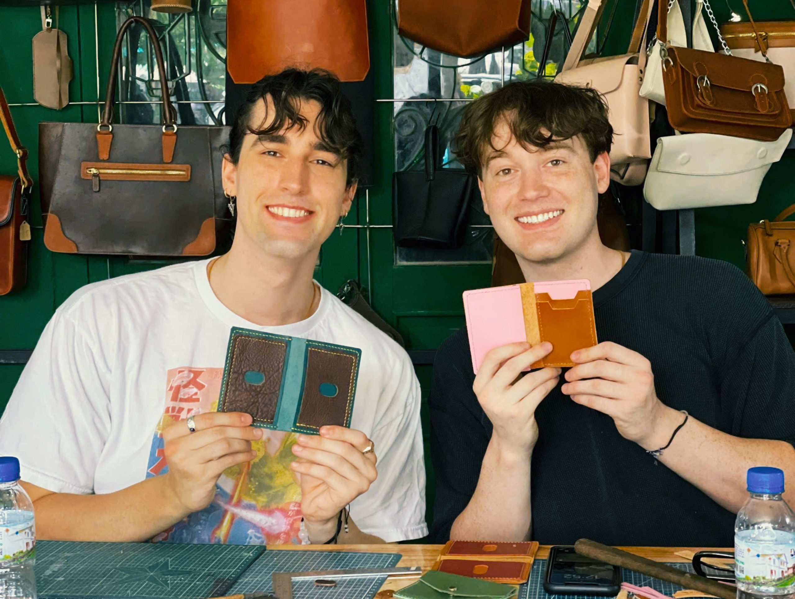 Guests Show Their Handmade Projects at Meadows Leather Workshop in Hoi An Two guests holding their handmade leather projects at Meadows Leather Workshop in Hoi An